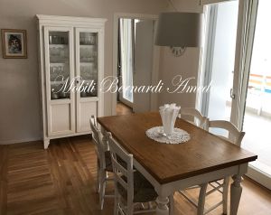 Vetrina in legno stile country con altri mobili da soggiorno e cucina nello stesso stile e finitura